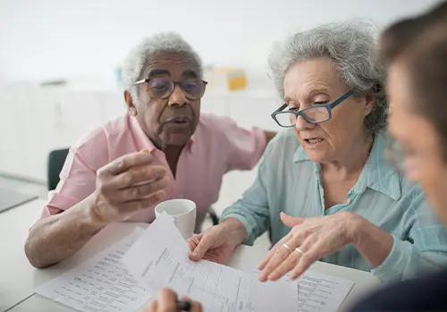 Licencensed insurance agent explaining policy options to prospective clients.